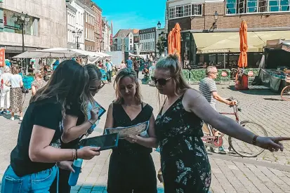 Groep deelnemers speelt een citygame in de binnenstad van Nijmegen als onderdeel van een groepsuitje